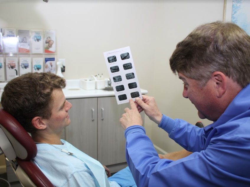 Dr. Silliman showing x rays to a male patient